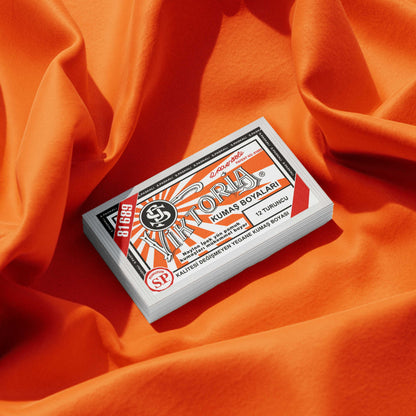 Pack of orange fabric dye placed on a vibrant orange fabric background