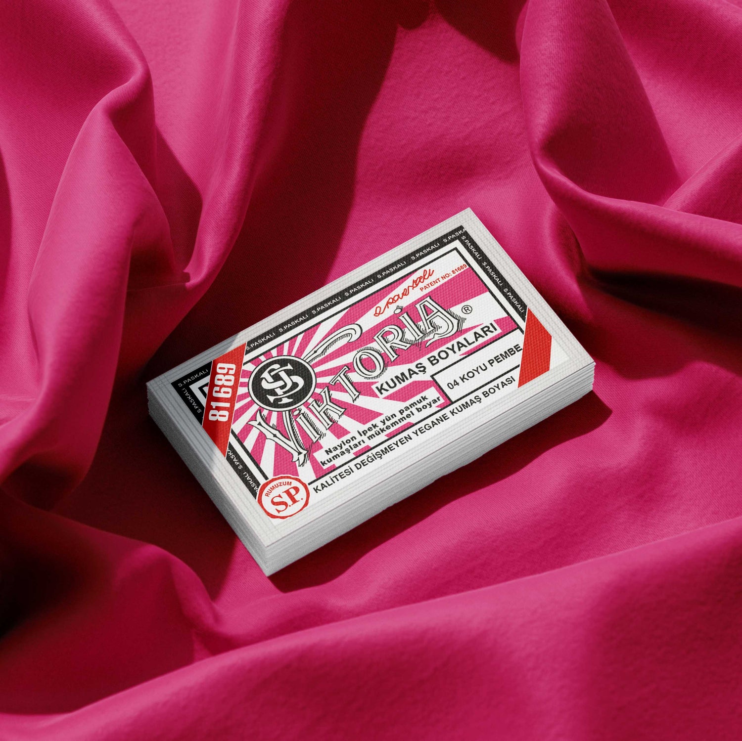 Pack of dark pink fabric dye placed on a vibrant pink fabric background